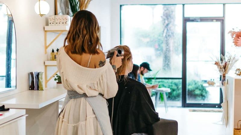 A client getting her hair styled at a salon